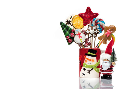 A festive holiday candy bouquet nestled in a charming snowman-designed container, adorned with a jolly Santa figurine, gingerbread cookies, and whimsically shaped lollipops.