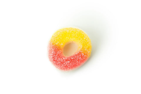 A close-up view of a yellow and orange peach gummy ring.