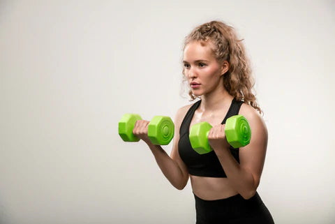 Woman in black vest with green dumbbells