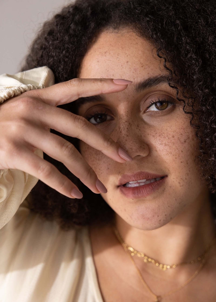 woman with olive skin and freckles wearing Rosie dusty pink nail polish by sienna