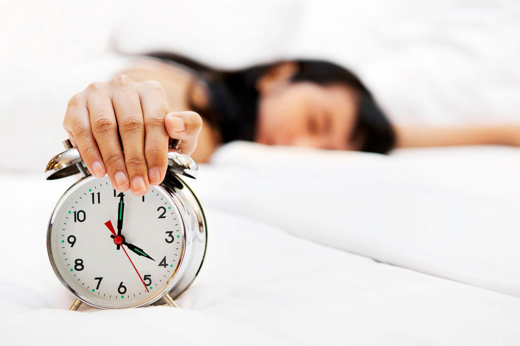 woman sleeping holding clock