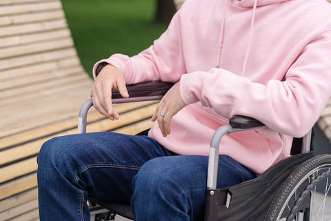 Person in Pink Hoodie and Blue Denim Jeans Sitting in a Wheelchair