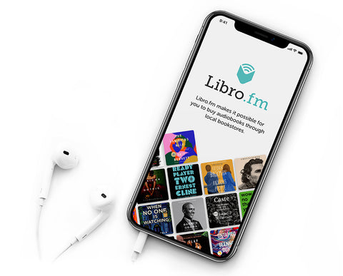 A picture of an iphone on a white background. White headphones are attached. On the screen is the title "Libro.fm" and pictures of bestselling books available as audiobooks.