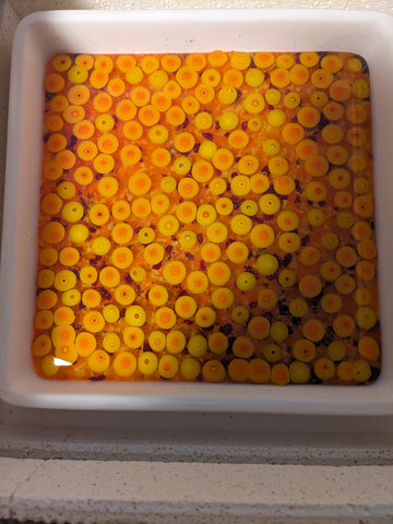 kiln with a finished slab of fire colored glass with murrine on the top layer