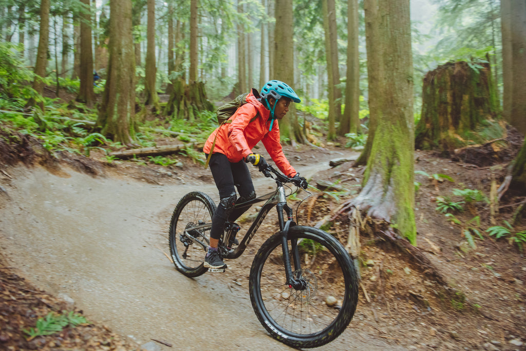 Judy Milay takes on the trails on a mountain bike amongst a forested backdrop on Canada's west coast