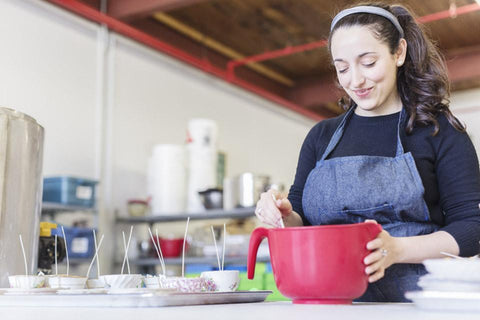 Anne Dardick in the Montreal Dot + Lil studio creating their signature tea-cup candles 