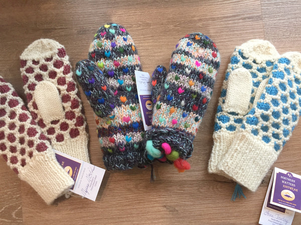 Three pairs of Northern Watters knit mittens laid in a row