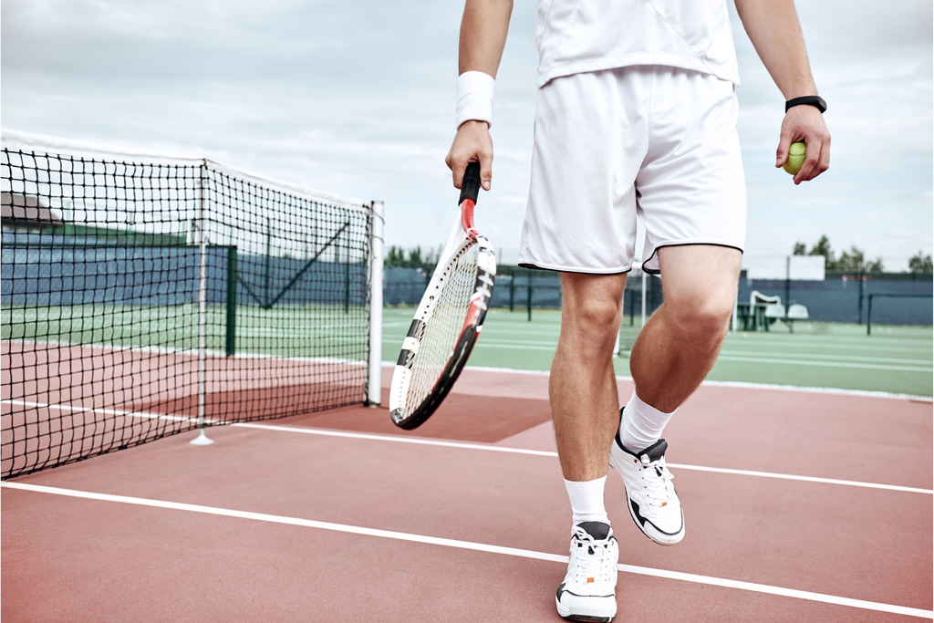 Tennisspieler am Netz in Tenniskleidung und mit Ausrüstung