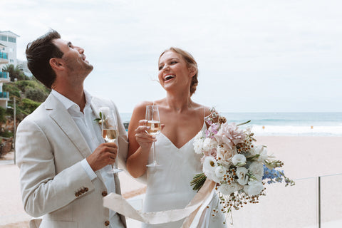 Bride and Groom laughing with personalised champagne flutes