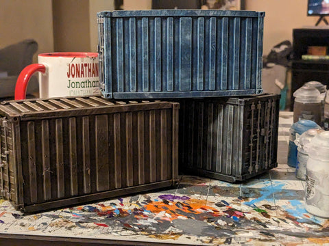 there are three containers stacked, a dusty blue, rusty brown, and dusky grey.