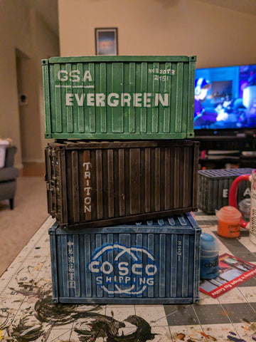 Stacked containers with company logos stenciled on them.