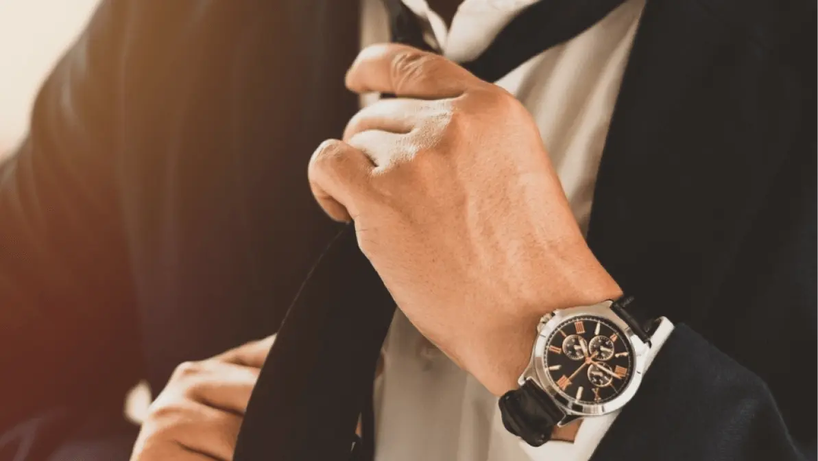 confident businessman in a black tie show elegance with a gold luxury watch on his left wrist, reflecting success and refined professional style.
