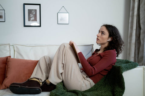 Woman listens to music on couch