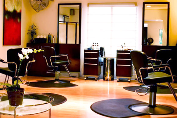 Interior, Marco Pelusi’s hair studio decorated in rich brown accents, a white orchid sits on table