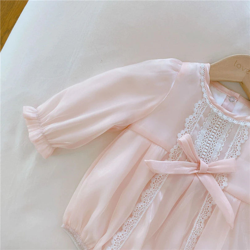 Pink long-sleeve Spanish baby bubble romper onesie with lace embroidery, silk bows, and matching headbands for reborn girl dolls.