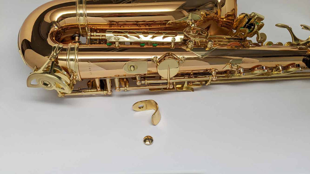 Alto saxophone thumb hook removed with screw and hook shown by alto sax body