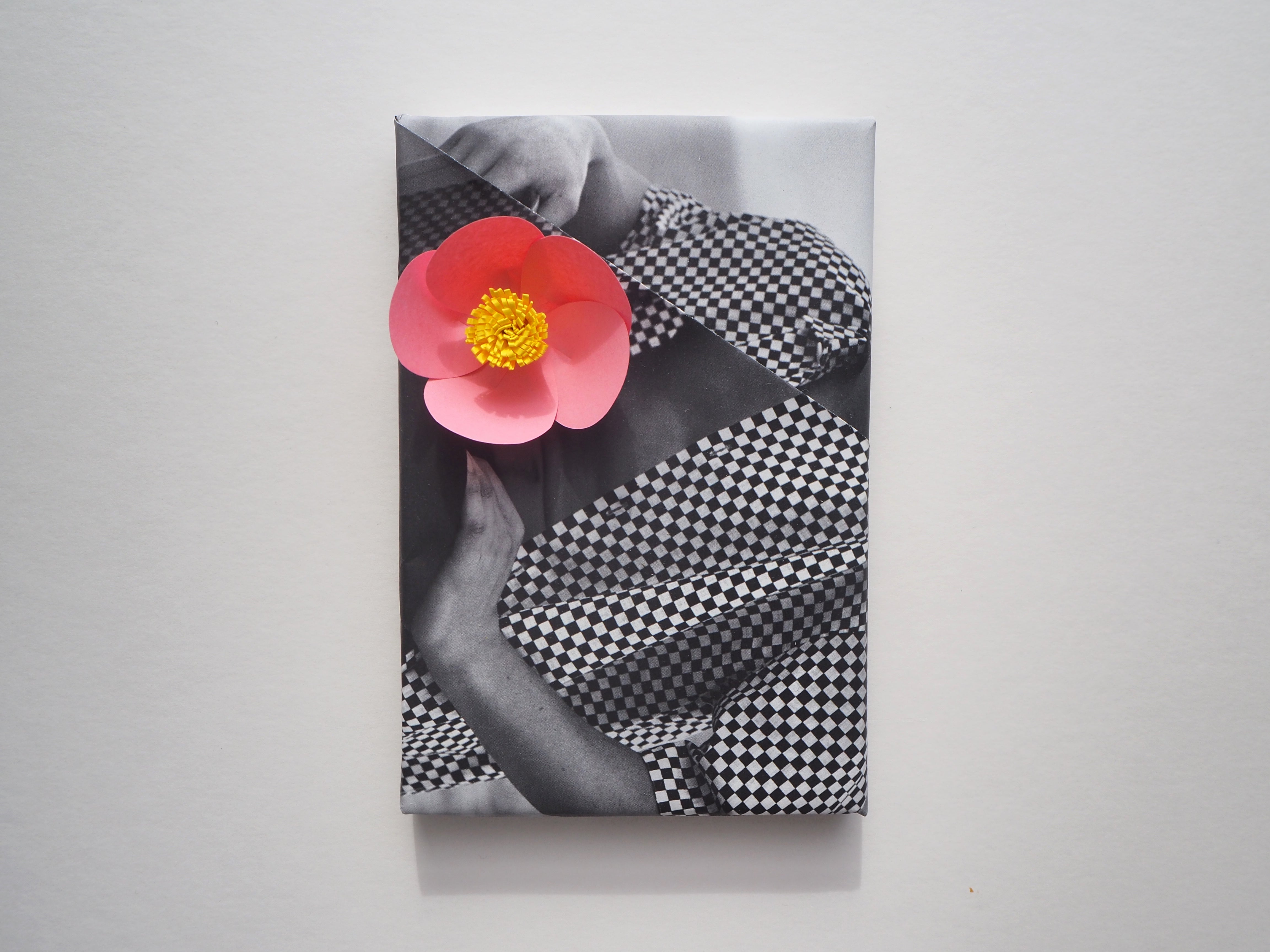 idea para envolver regalos reciclados con papel de revista y una flor hecha a mano con papel