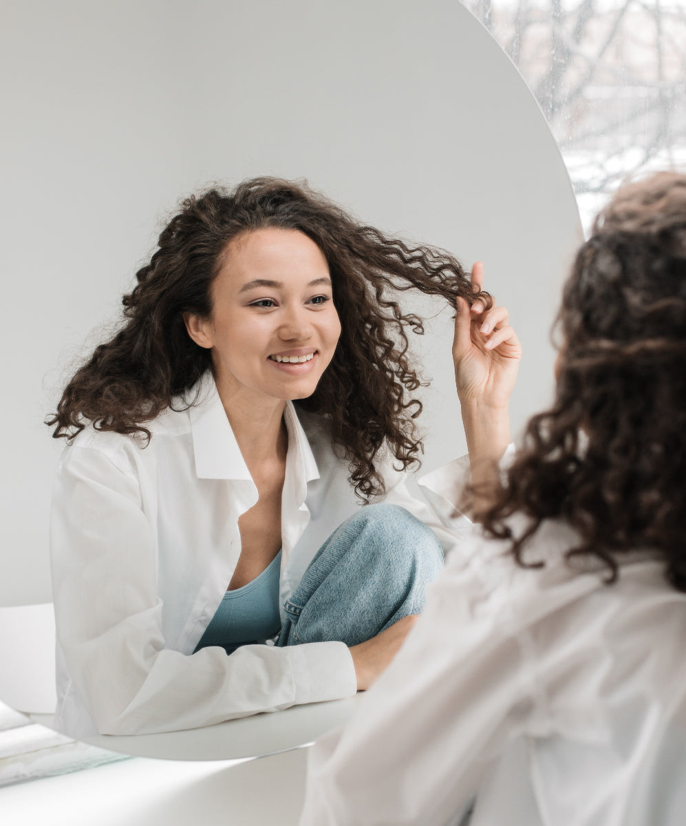 woman looking in reflection using reflection is the key to creating a successful vision board for powerful manifestation tips