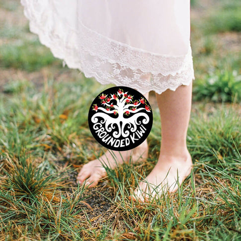 Lady standing barefoot on grass showing how to earth.