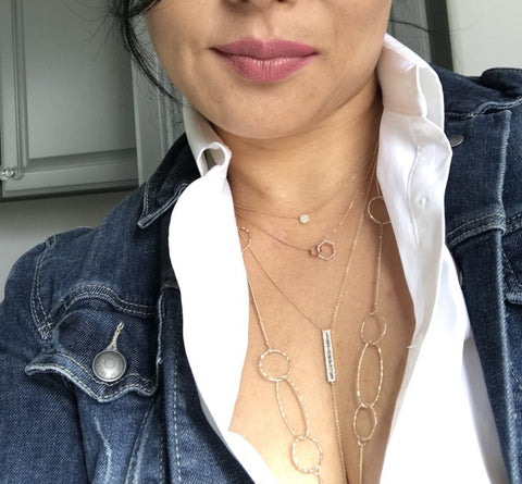 four layered gold necklaces with white shirt and jean jacket