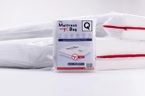 a creative photo of the mattress bag packaging standing up with two mattresses behind it that are both in mattress bags with red zips
