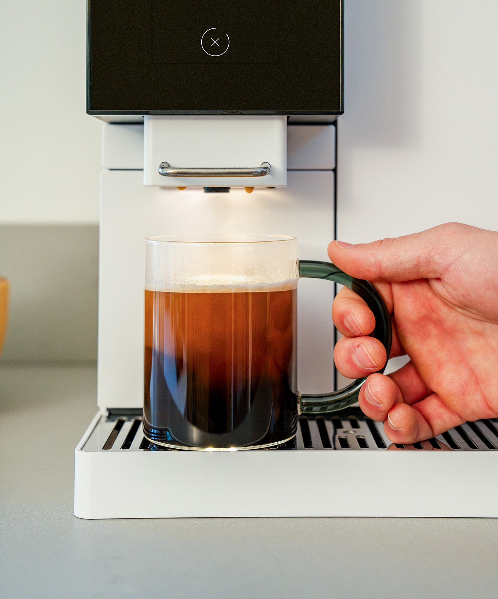 Person grabbing glass mug after coffee drink was brewed