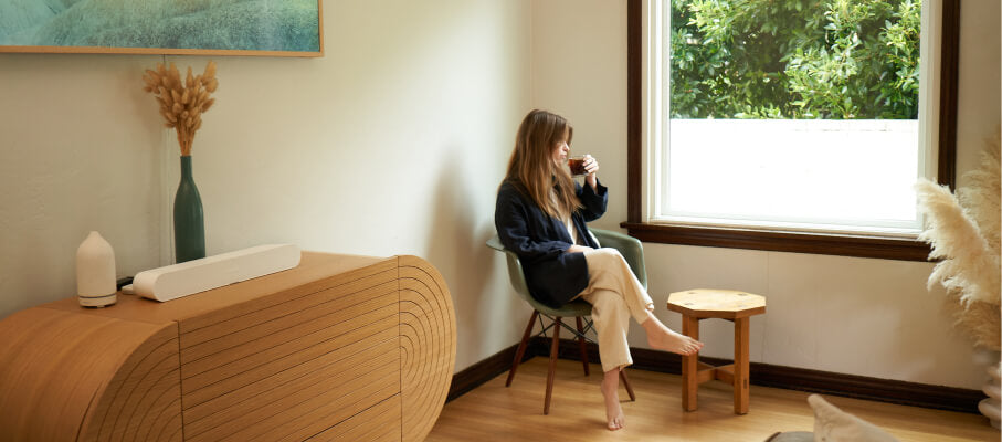 person sipping coffee next to window