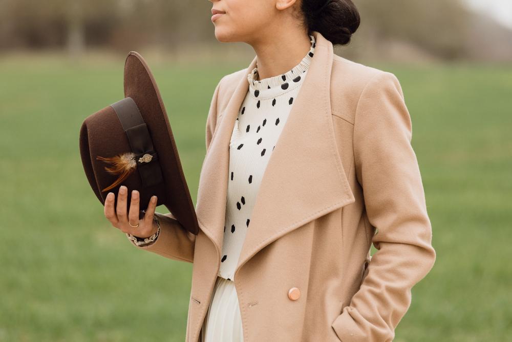 A woman holding a brown Christys' fedora