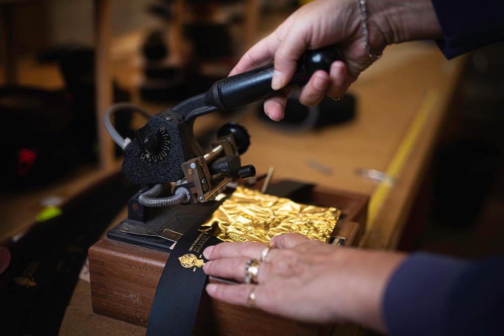 A woman using a Christys' gold foiling machine