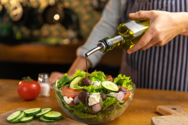 organic_olive_oil_being_poured_into_a_bowl_of_salad