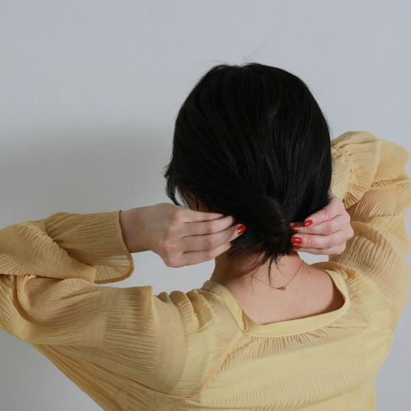 左寄りでくるりんぱをします。ゴムを毛先にずらし、今度は右寄りでくるりんぱをします。毛先を右上に引っ張り、最後に毛先をクリップで留めて完成。