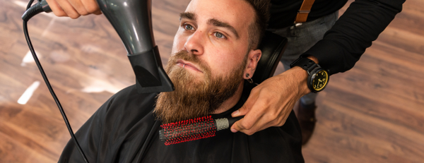 Man having his beard blow dried in a barber shop