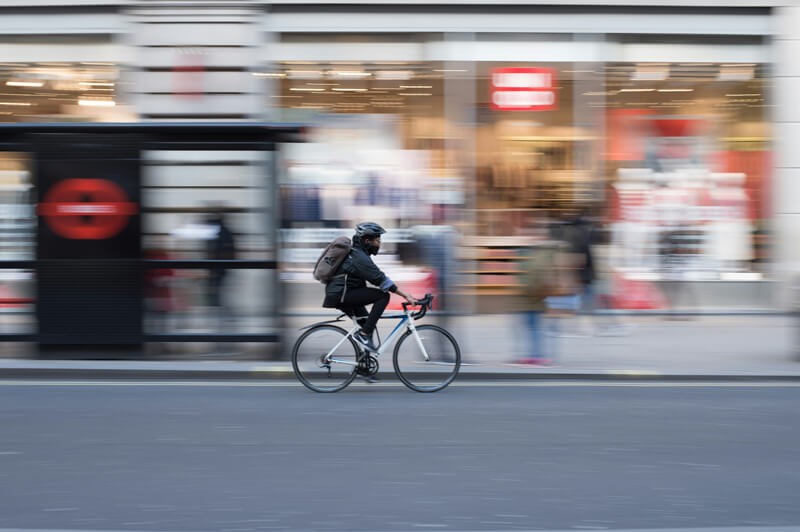 a man wearing a helmet rides an e-bike on the road