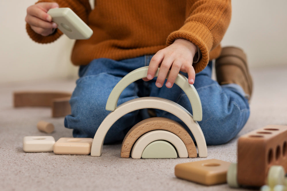 A little kid playing with wooden arches toys