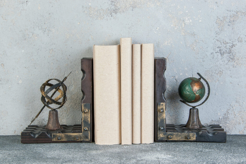 Antique book ends and books on table on gray background