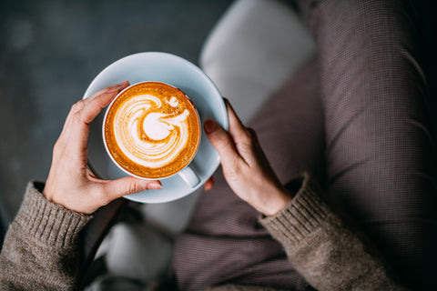 Hands holding a cup of coffee. 