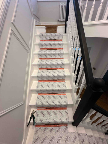 Underlay fitted to a white staircase ready for a runner