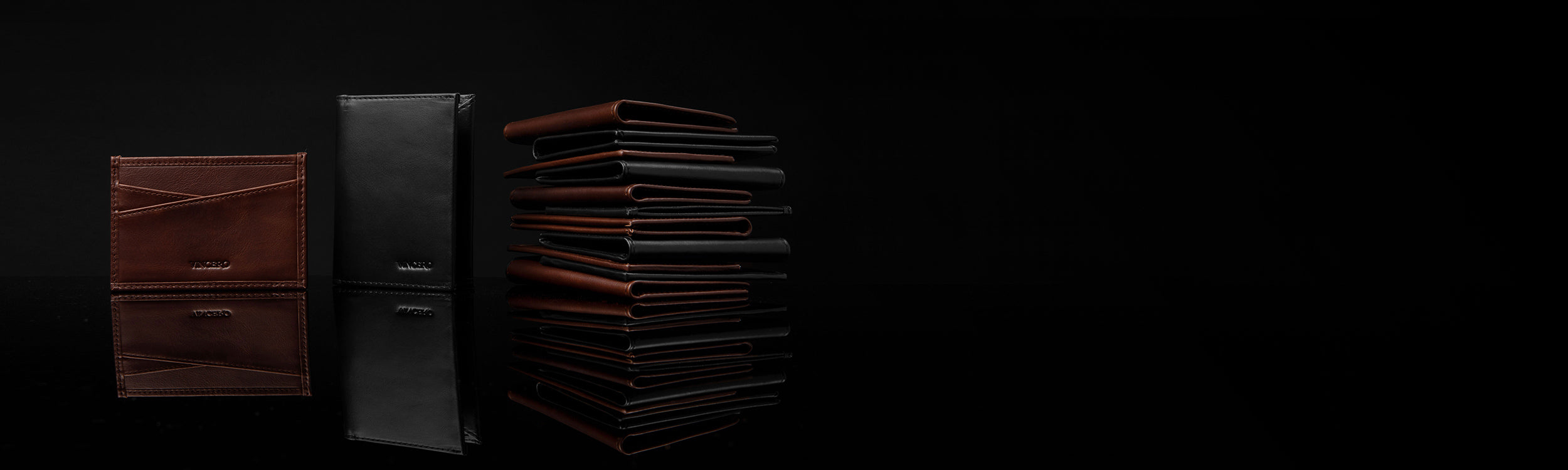 Brown wallet, black wallet, and stack of wallets with bottom reflection in black background