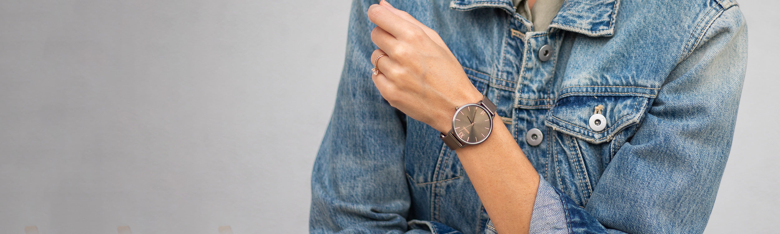 Woman in denim jacket wearing dark khaki watch