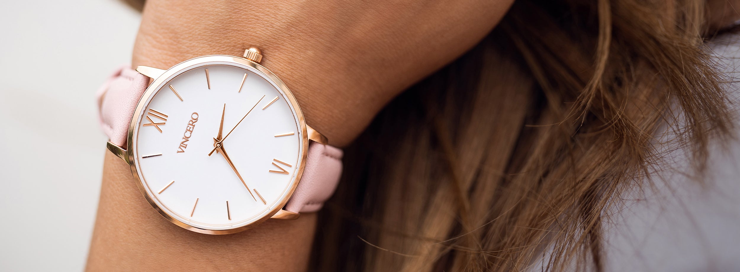 Close up of white and rose gold watch with rose pink leather strap