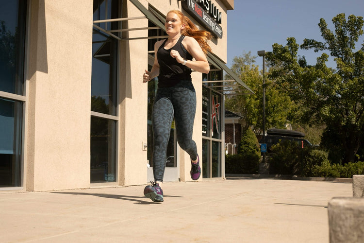 A woman runnnig in KURU QUANTUM fitness shoes for running.