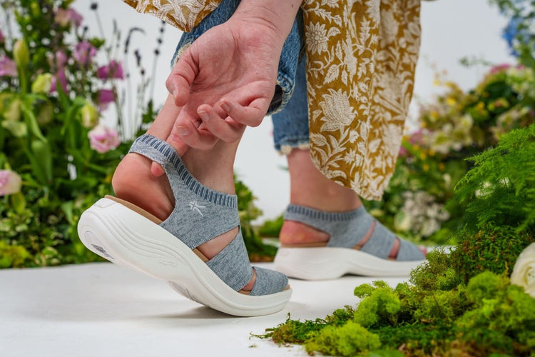 A woman wearing light blue sandals.