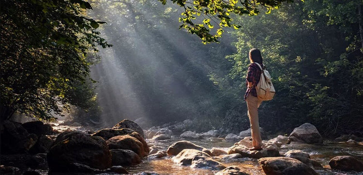 woman standing on river boulder wearing waterproof shoes