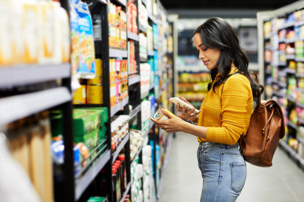 Une femme qui compare les produits dans un supermarché