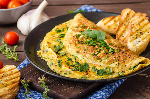 Une omelette avec des herbes sur le dessus dans une assiette