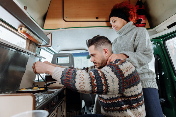 couple cooking in a caravan