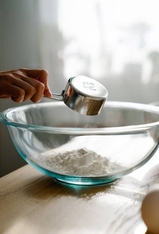 Measuring cup used to measure out flour into a glass mixing bowl. Photo by Felicity Tai.