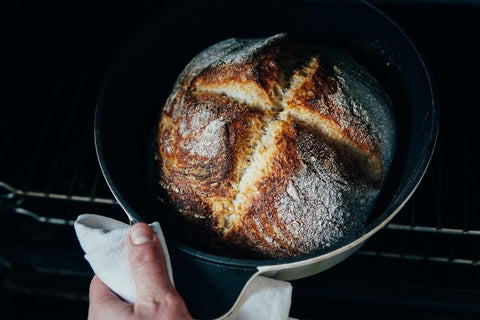 Removing bread baked in a cast iron Dutch oven. Photo by Elle Hughes.