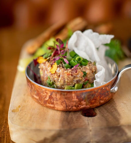 A copper pan utilized as serving ware.