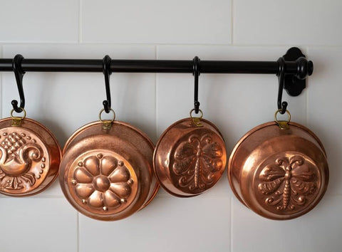 Vintage copper baking pans hanging in the kitchen. Photo by Ron Lach.